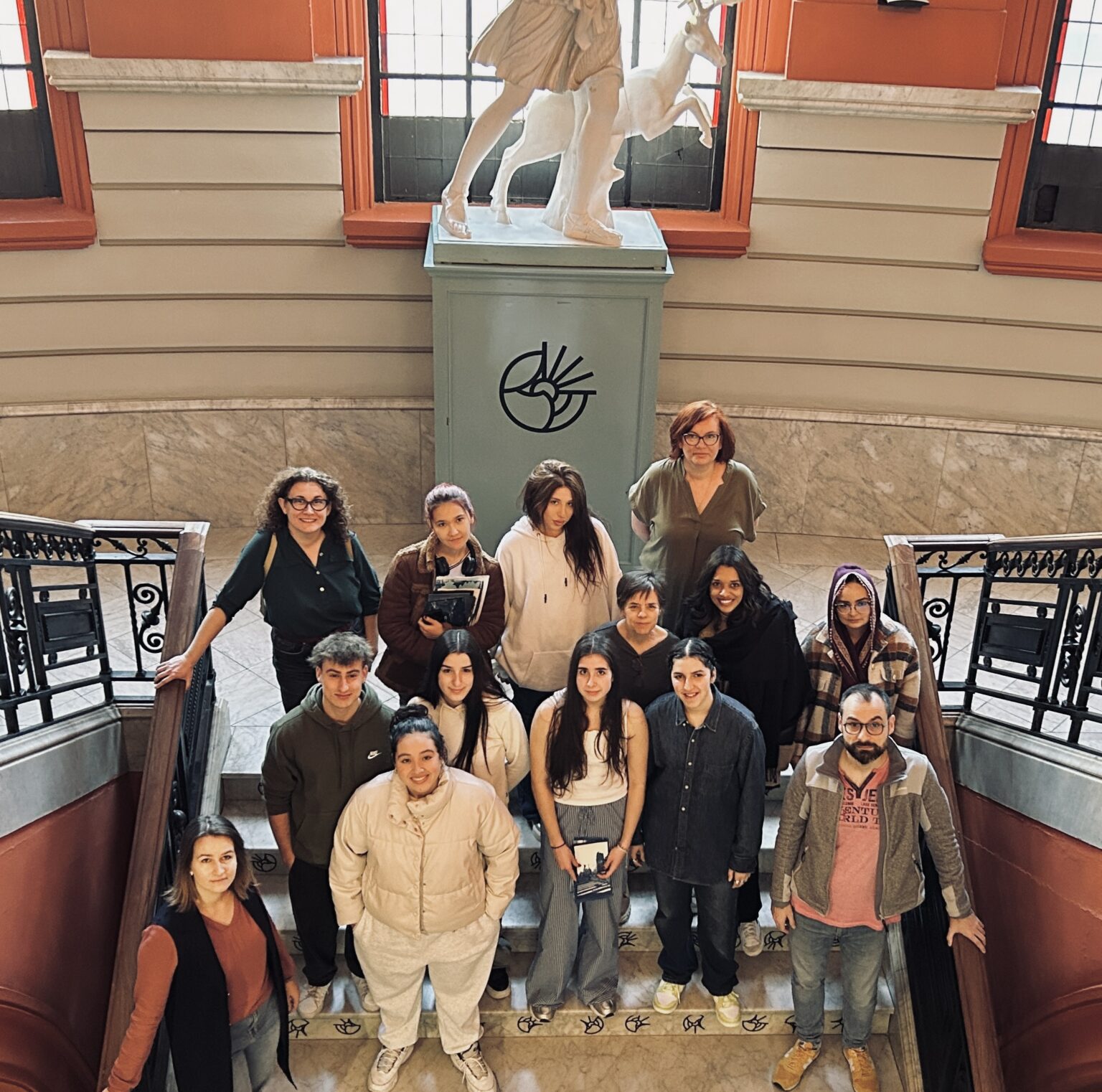 Uczestnicy warsztatów na schodach uczelni partnerskiej